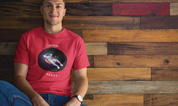man-wearing-a-tshirt-mockup-while-sitting-against-a-wooden-wall-a17849